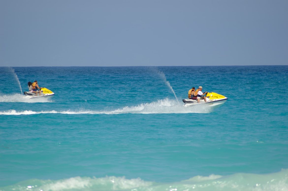 Yellow jet skis race across the water. Toys like these are available on your yacht charter.