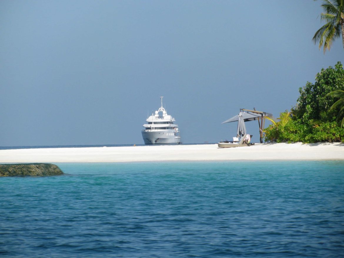 Luxury superyacht anchored near deserted beach