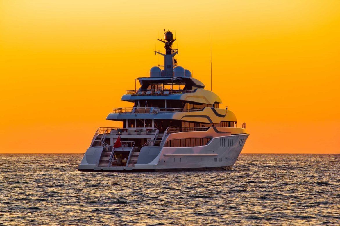 Dramatic shot of a luxury yacht at sunset