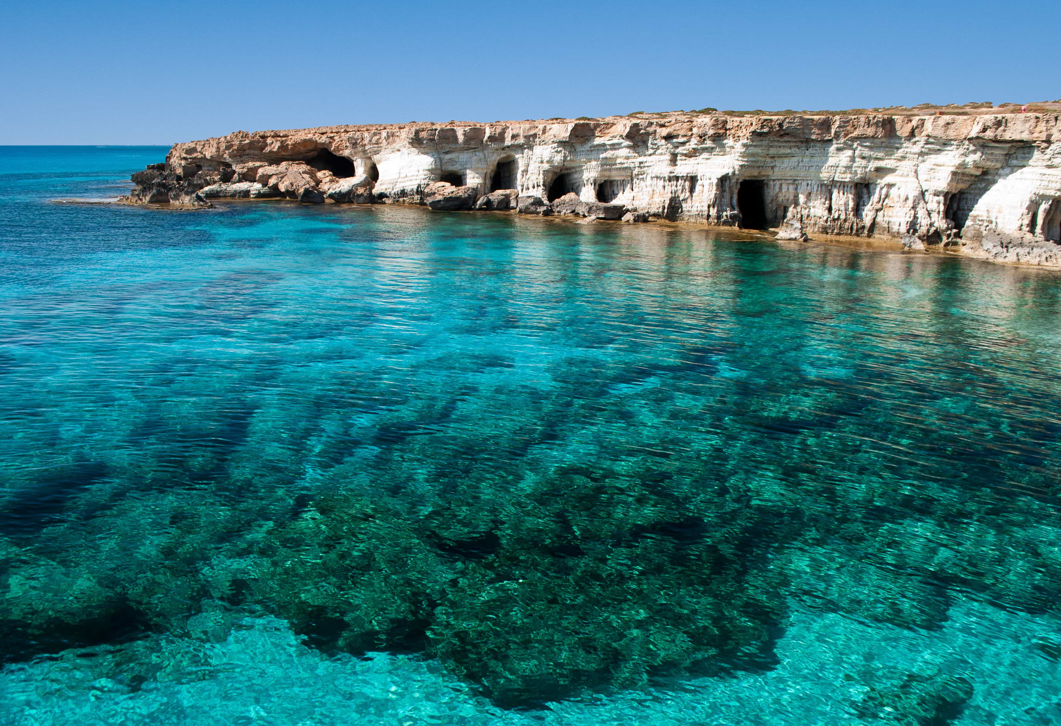 blue lagoon in Cyprus with rock cliffs around