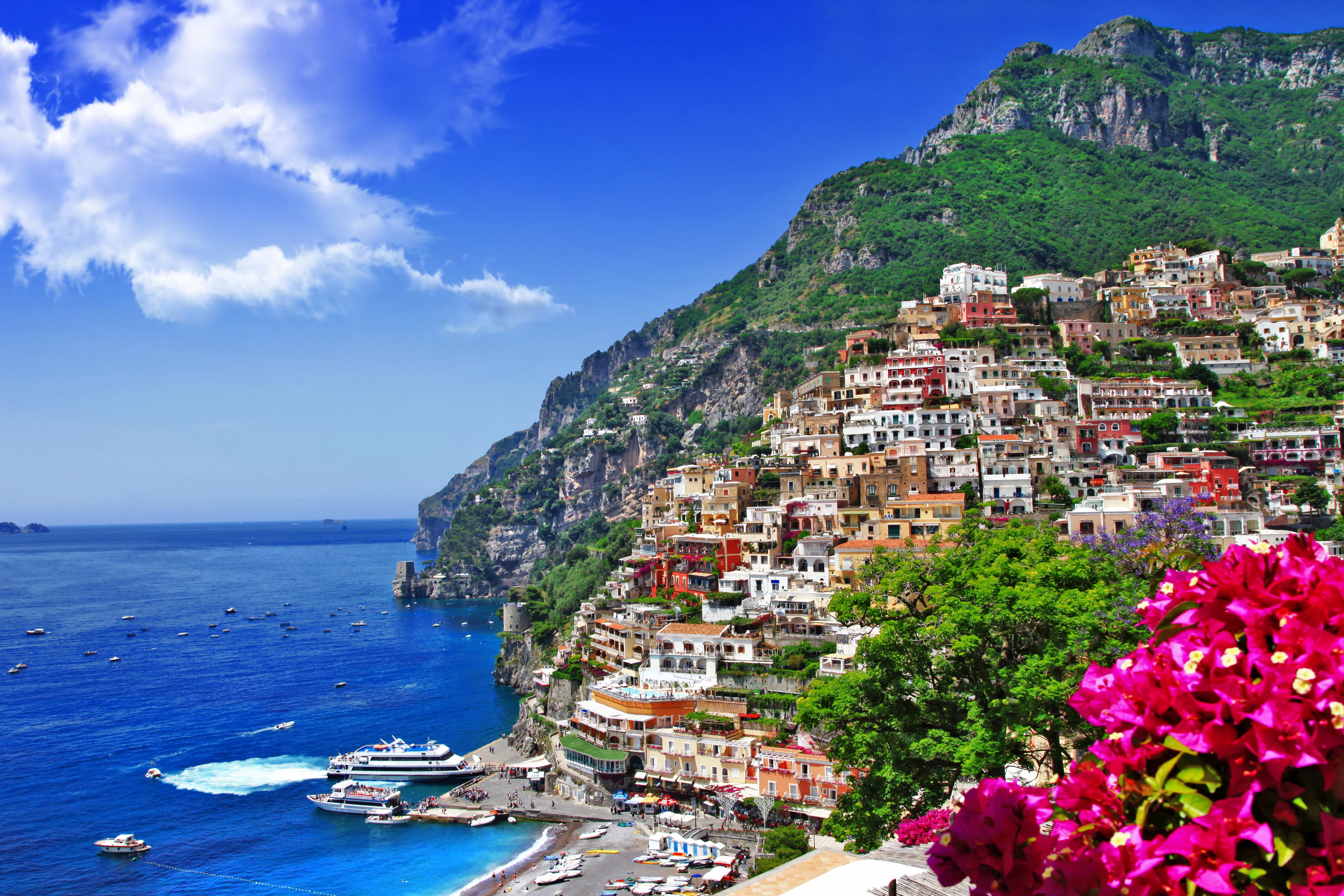 Colorful buildings overlook a deep blue sea along the Amalfi coast in Italy