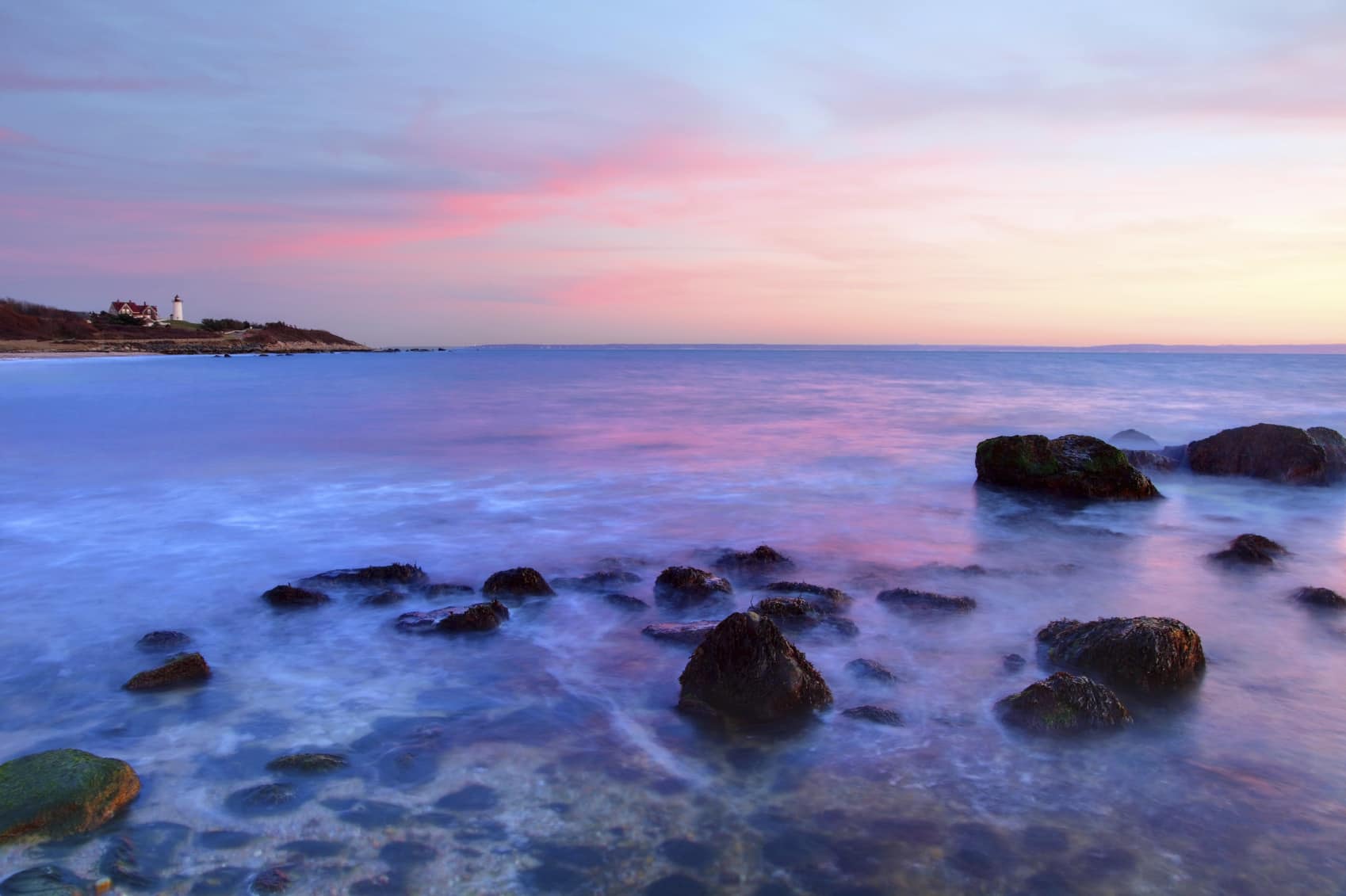 rocks popping out of the surf at sunset