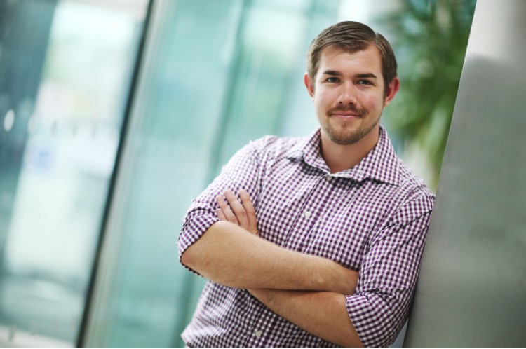 man leaning against wall smiling