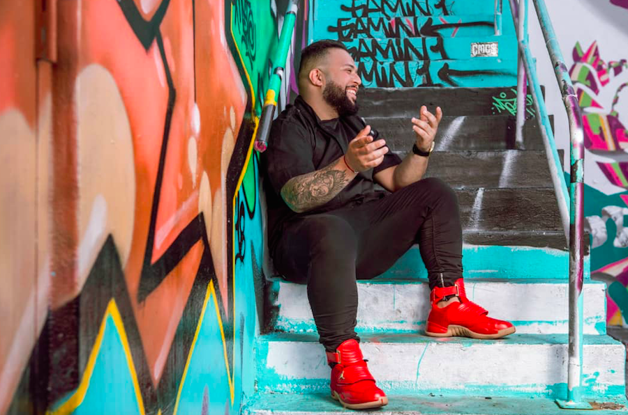 laughing man sitting on steps by graffiti wall