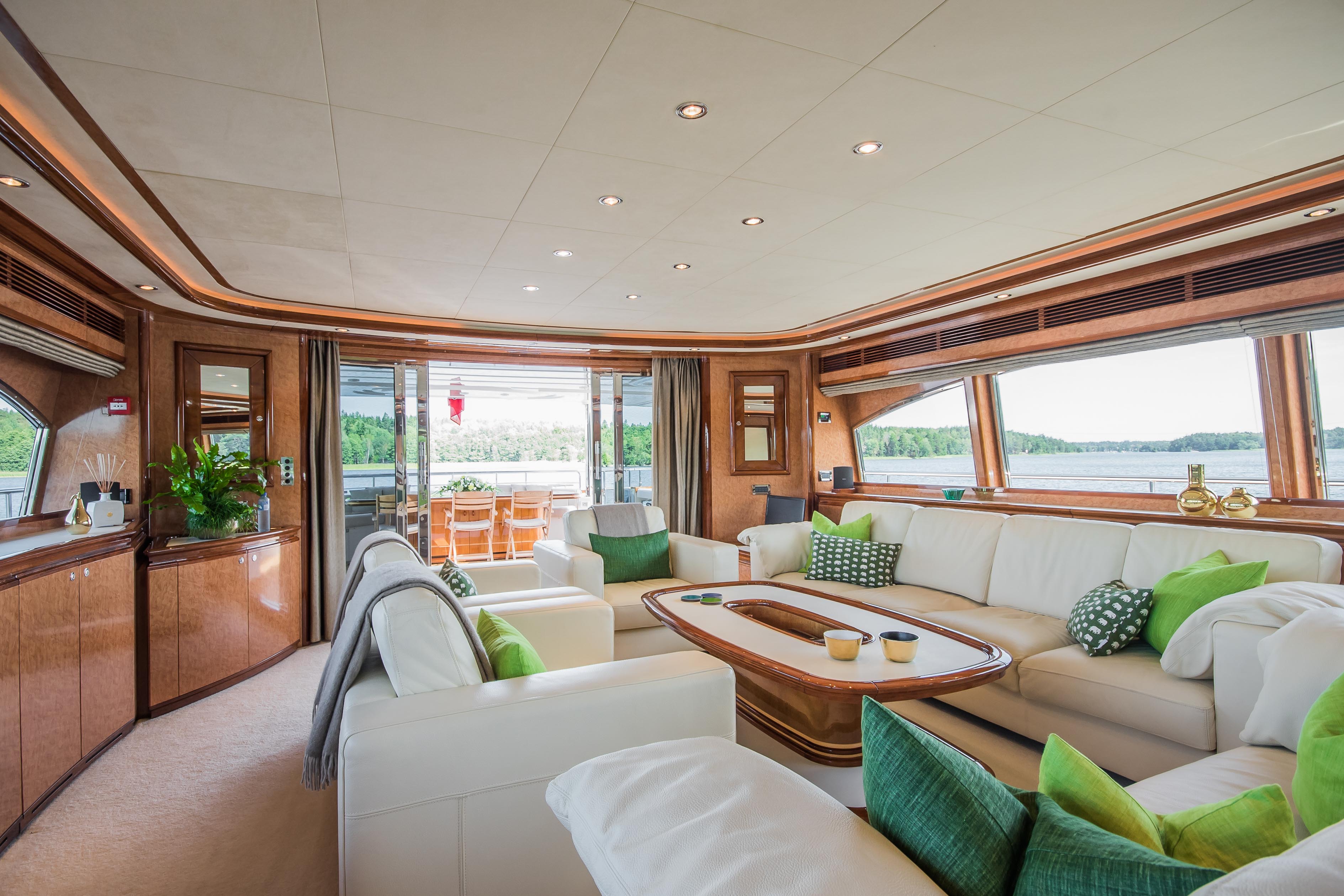 interior lounge on Queen of Sheba with white sofas, green accents and wrap around windows