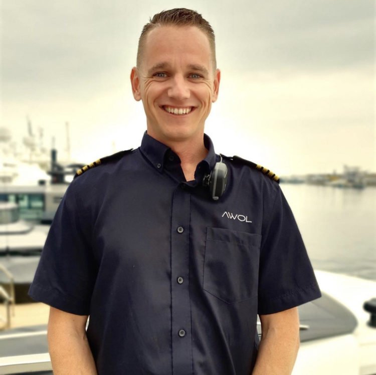 smiling male captain in uniform onboard luxury yacht