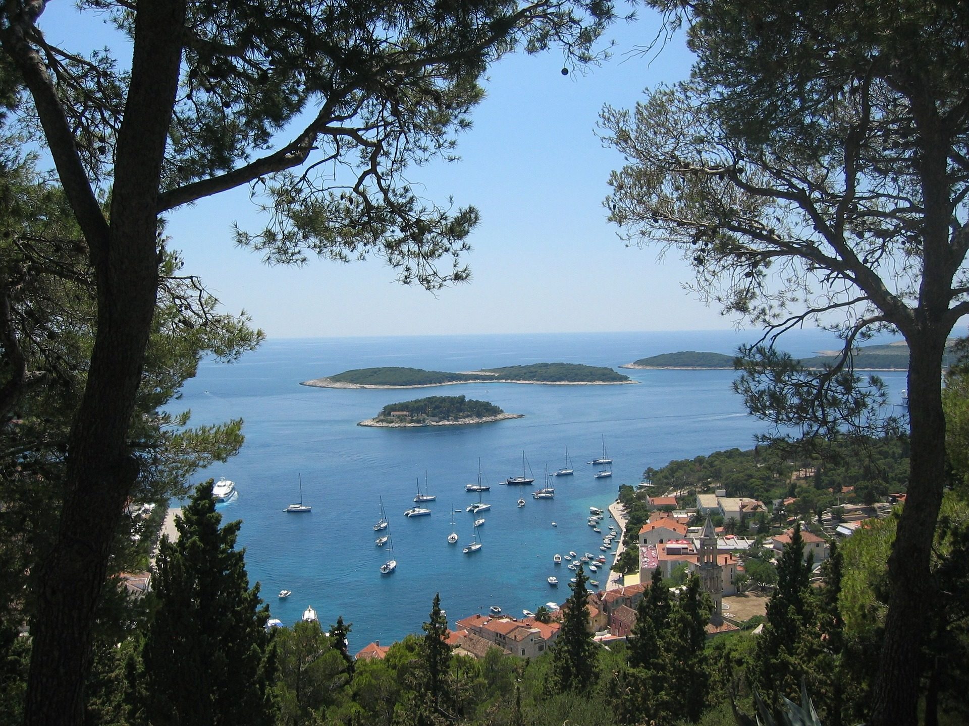 view of Hvar from up on a cliff with little islands and yachts dotted along the shore