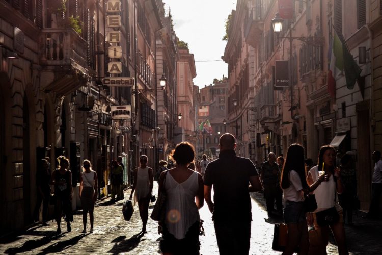 silhouette of man and woman at sunset walking amongst shops in Naples, Italy