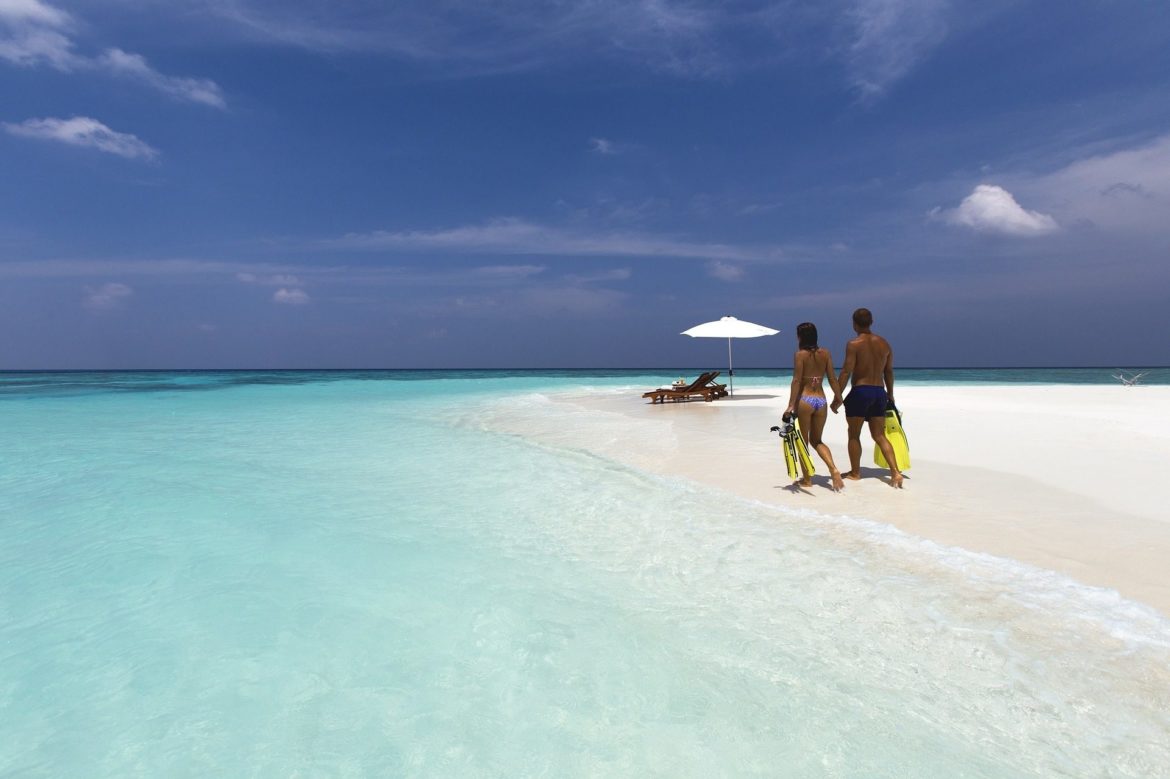 Two people walking on a secluded beach