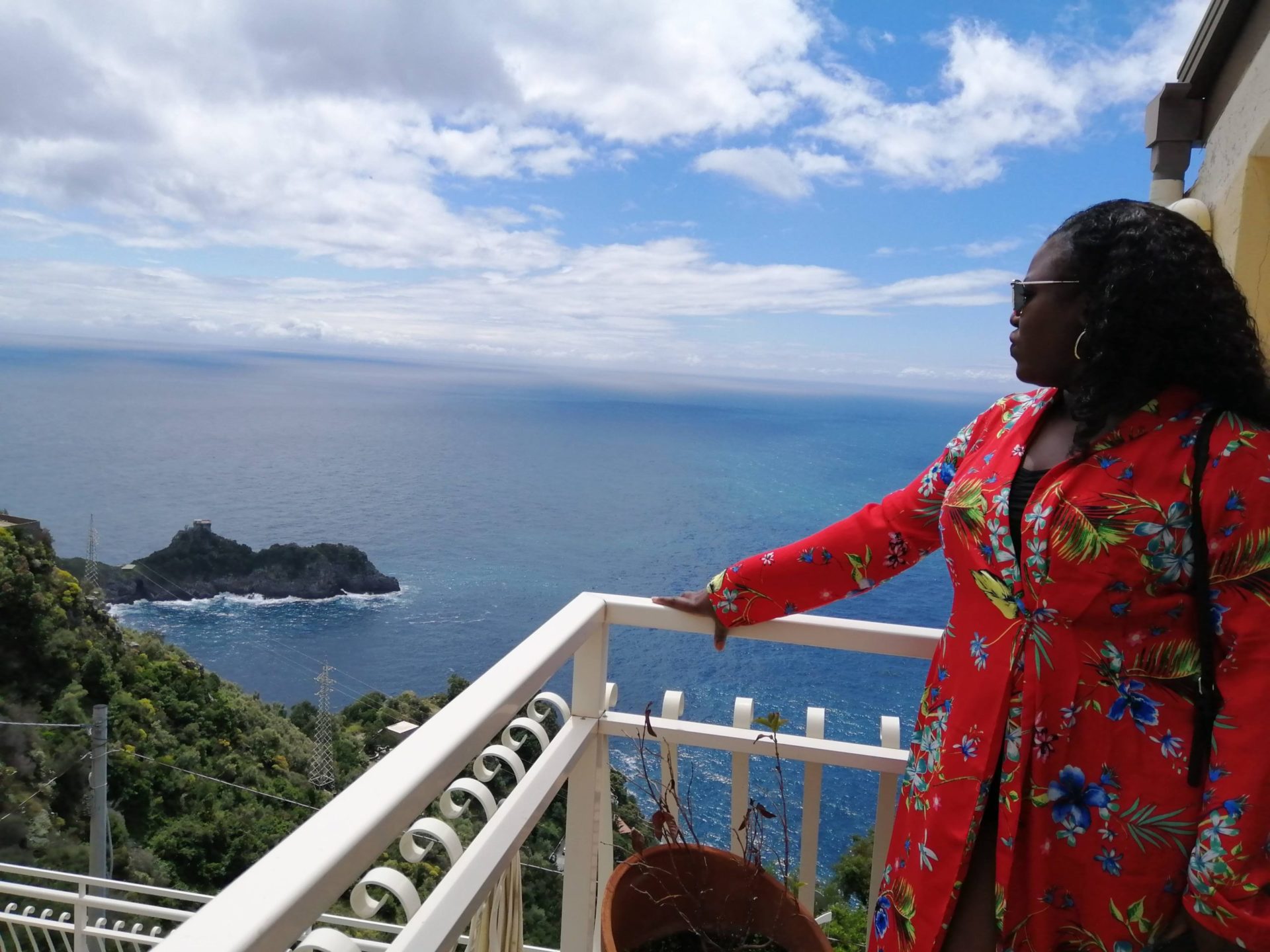Black woman standing on balcony overlooking the islands and ocean