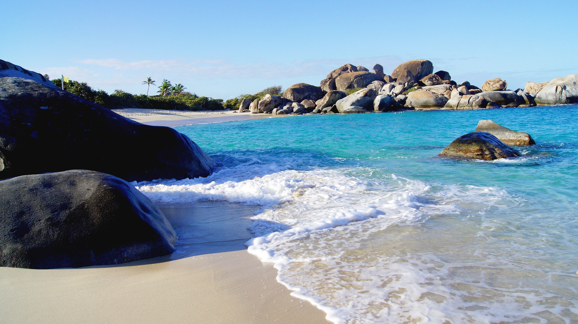 surf washing up on shore in US Virgin Islands with rocks all around