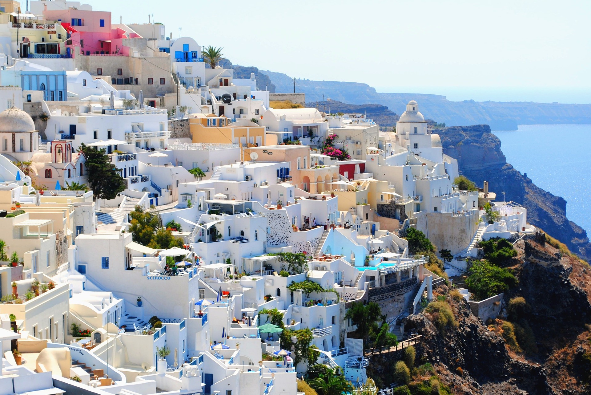 white washed buildings of Santorini on the cliffside with ocean below