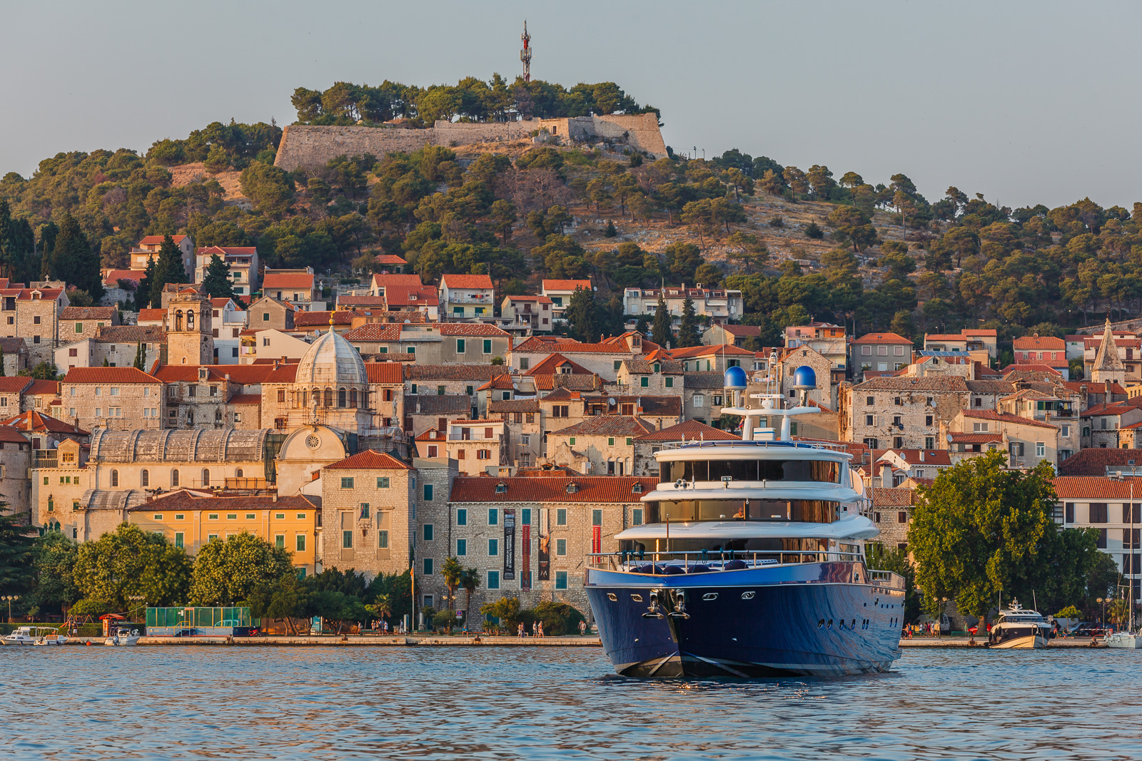 luxury yacht Johnson Baby with blue hull pulling away from port in Croatia