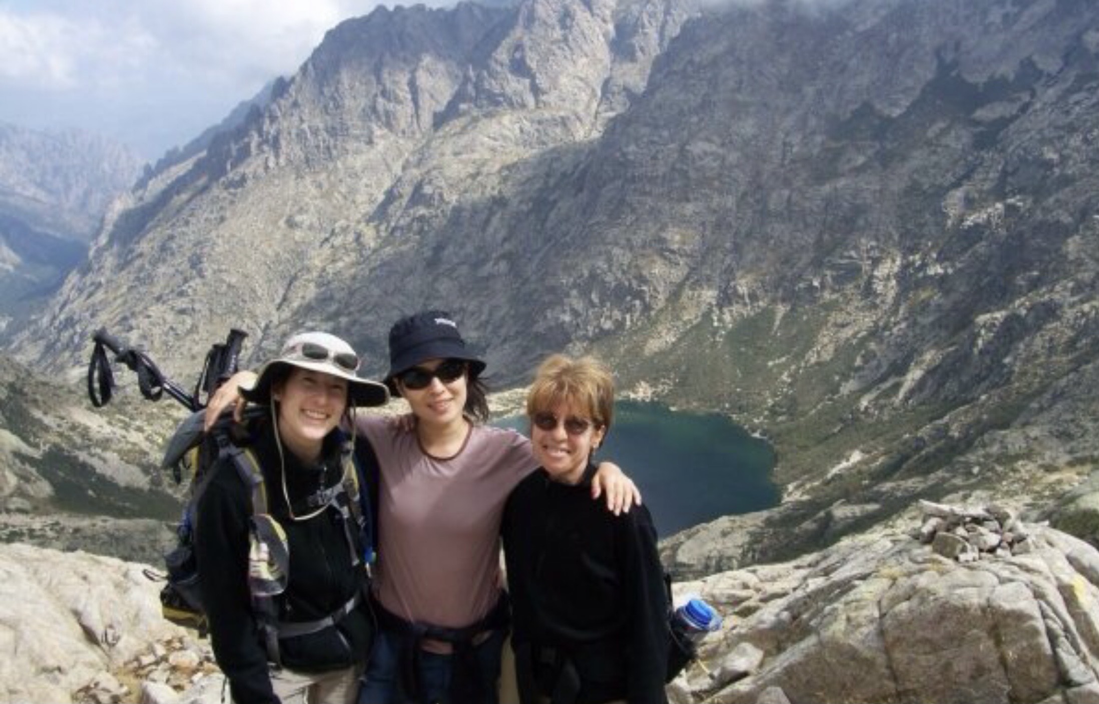 Jeanine Barone and two other women stand in front of lake on mountainside