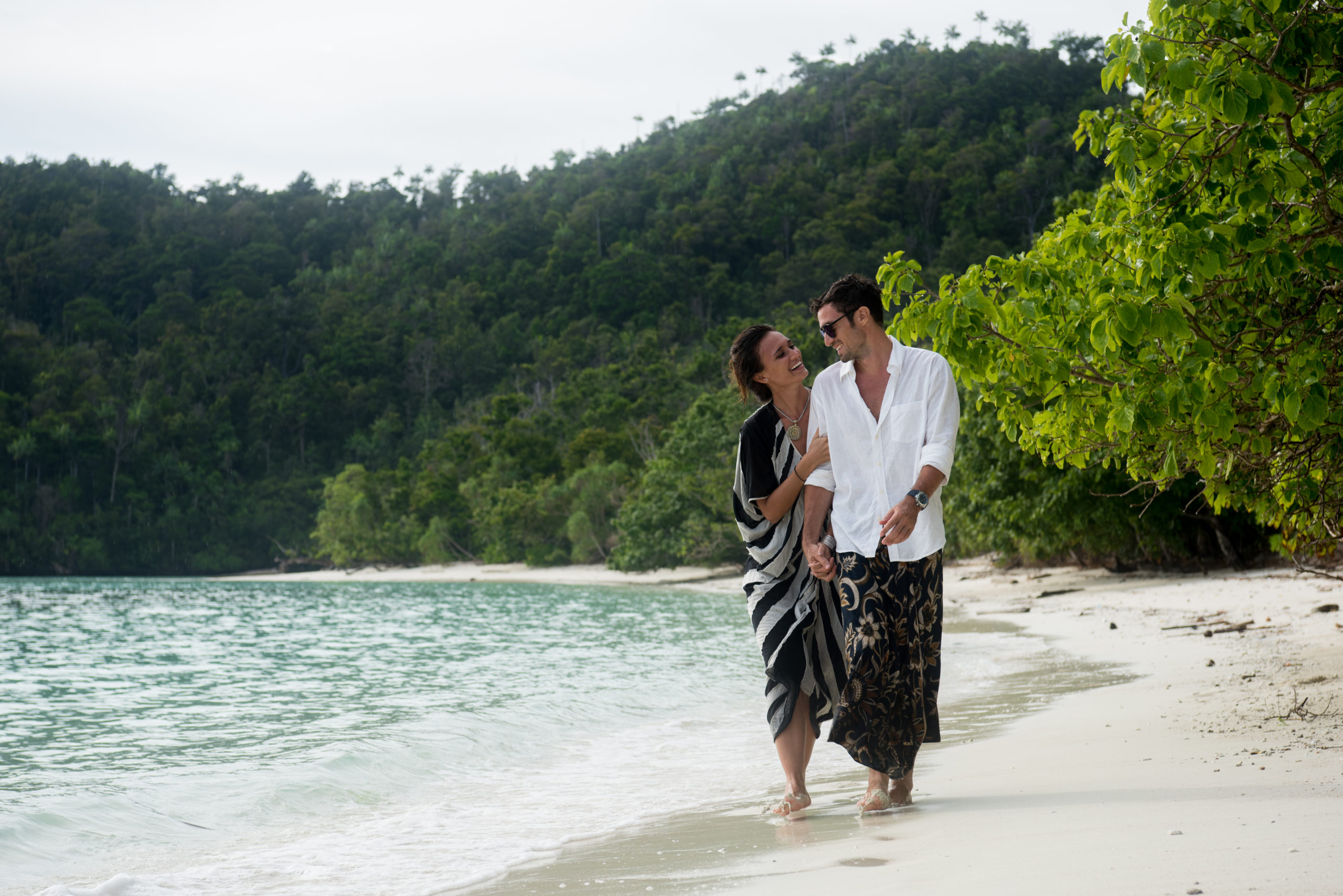 spoil mom with a luxury yacht getaway - woman and man walking on deserted beach